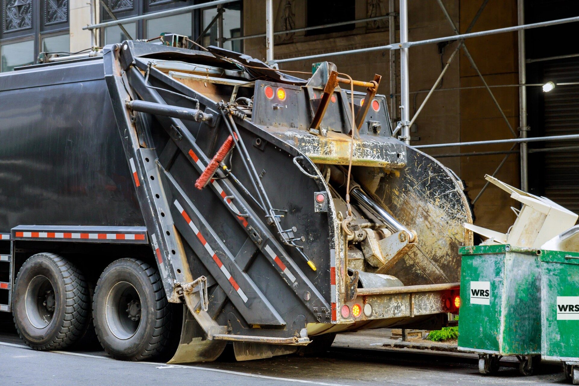 A collection truck emptying a container on a commercial site
